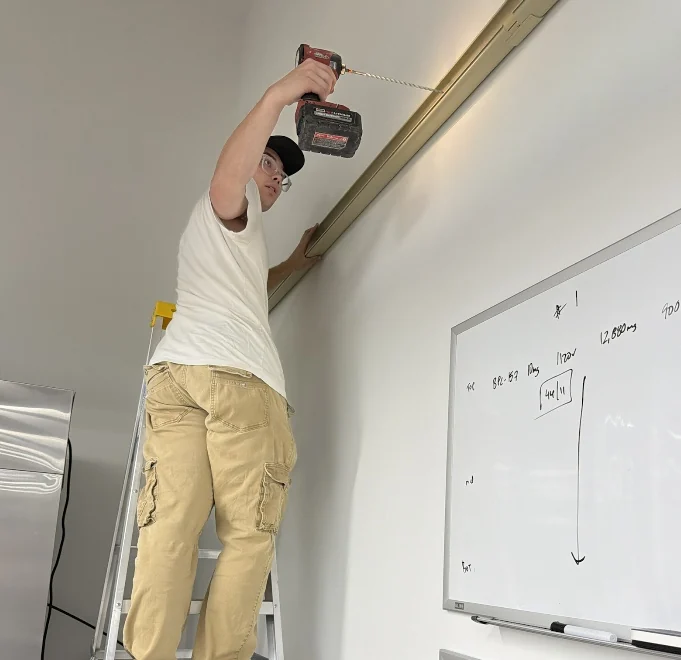 Technician preparing an indoor wall for installation